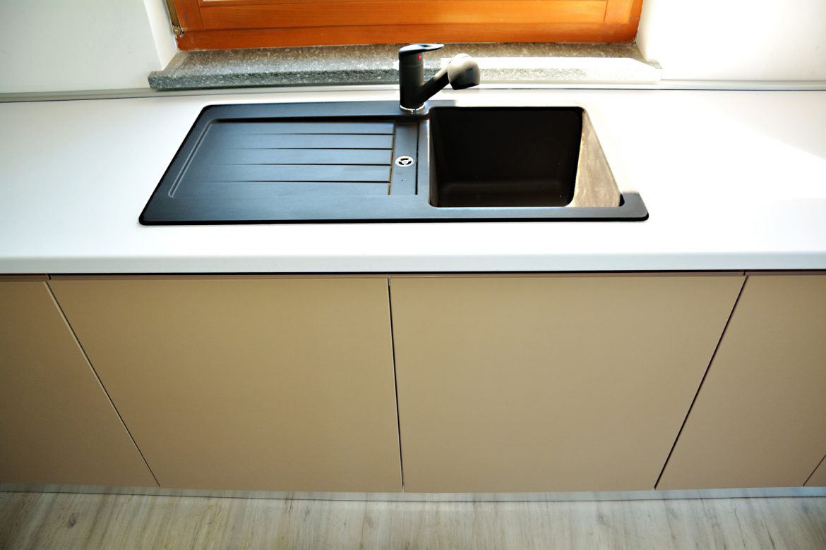 Bucatarie la comanda Yulmob Bacau detali chiuveta incastrabila din granit cu usi din MDF vopsite mat cappuccino RAL 1019 frezare maner cu balamale silentioase Blum
