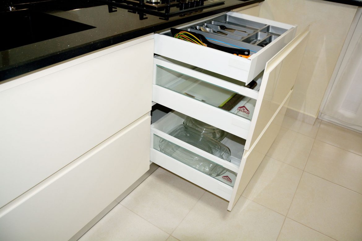 Bucatarie la comanda cu sertare silentioase cu amortizare Antaro Blum sertar ascuns pentru tacamuri inaltatoare sertar cu sticla usi MDF vopsit crem lucios RAL 9001 frezare manere