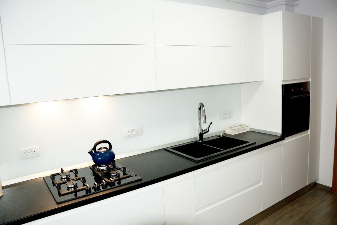 Bucatarie la comanda cu usi MDF vopsit alb lucios RAL 9003 cu frezare manere blat termorezistent negru electrocasnice incorporabile negre plinta apa PVC