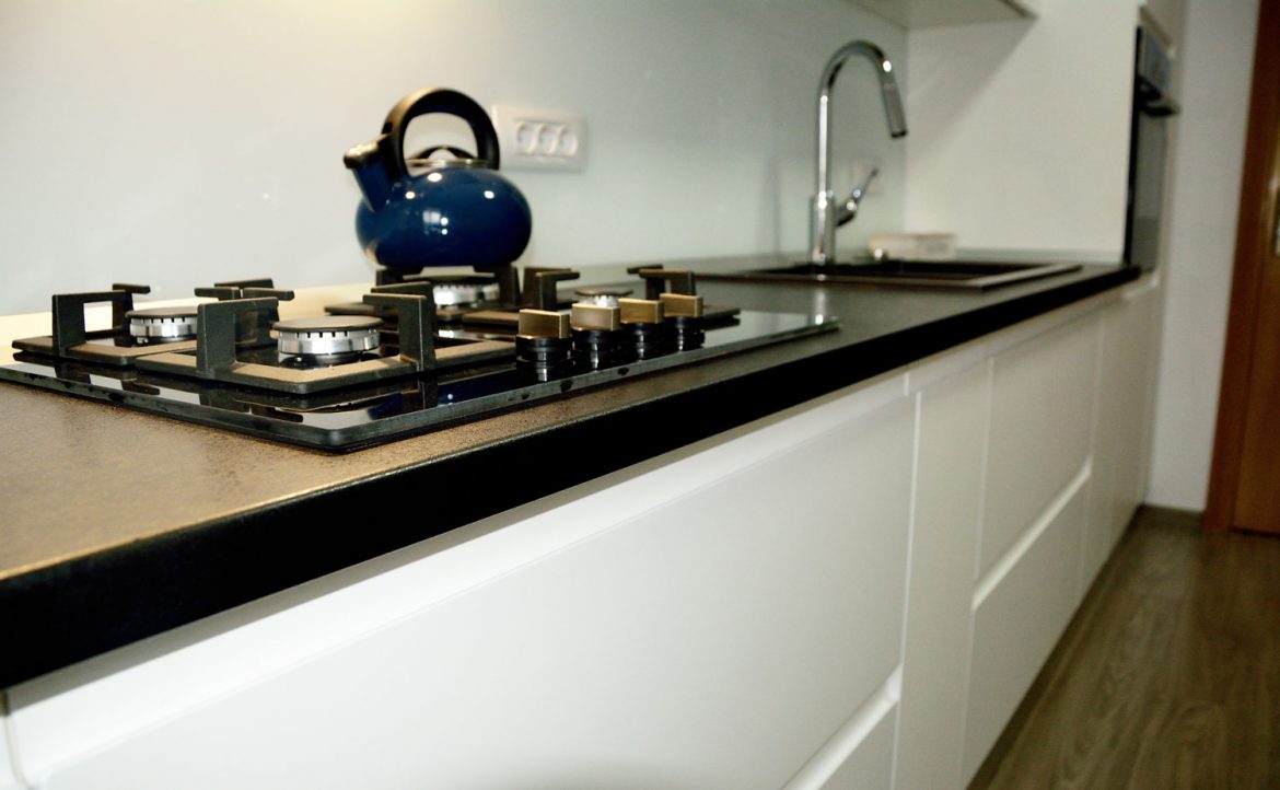 Bucatarie la comanda cu usi din MDF vopsit RAL 9003 alb lucios cu frezare manere si blat termorezistent negru 1